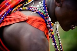 Tampilan jarak dekat dari seorang pria Masaï yang mengenakan kostum warna-warni di Kenya